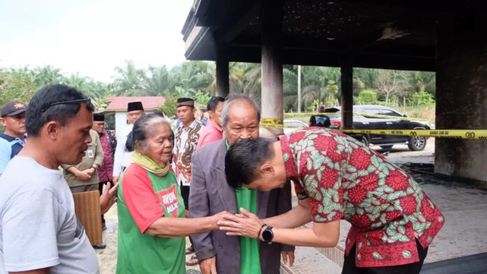 Bupati Kabu paten Muaro Jambi Bachyuni Deliansyah mengunjungi sekaligus memberikan ban tuan kepada korban keba karan rumah di Desa Panca Bakti, Kecamatan Sungai Bahar. (DOK)